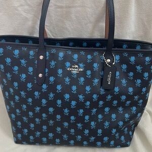 Navy Coach shoulder bag with blue flowers.